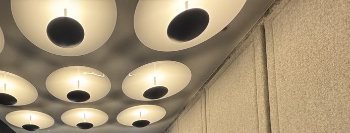 Ceiling installation of illuminated white disc lights with black centres