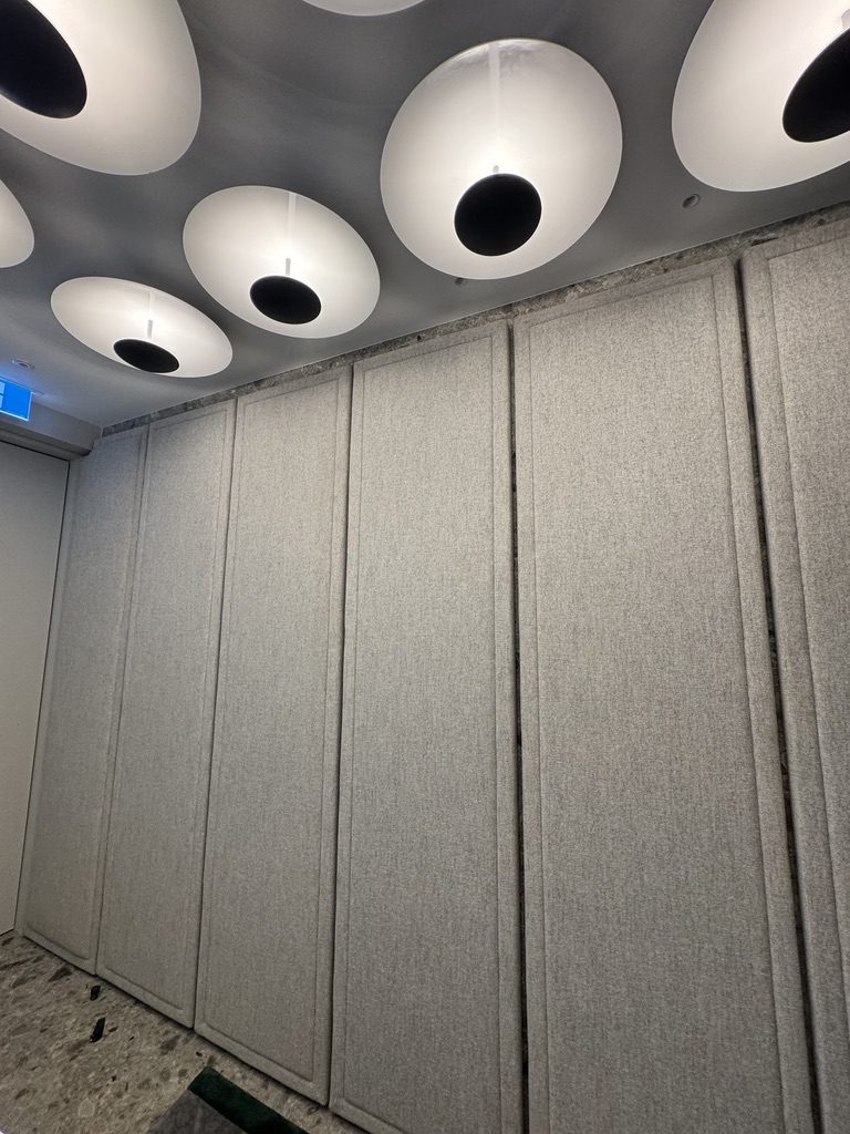 Disc lights above upholstered acoustic wall panels