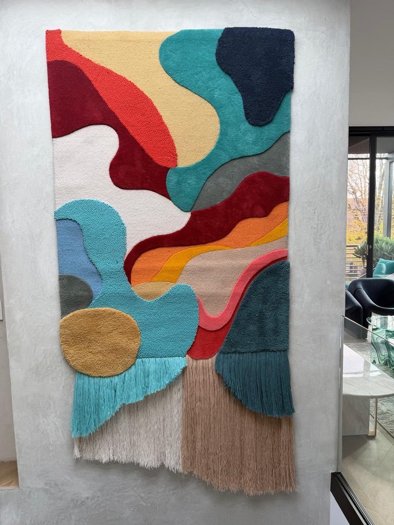 Hand-tufted abstract wall rug in teal, red and ochre with long fringe