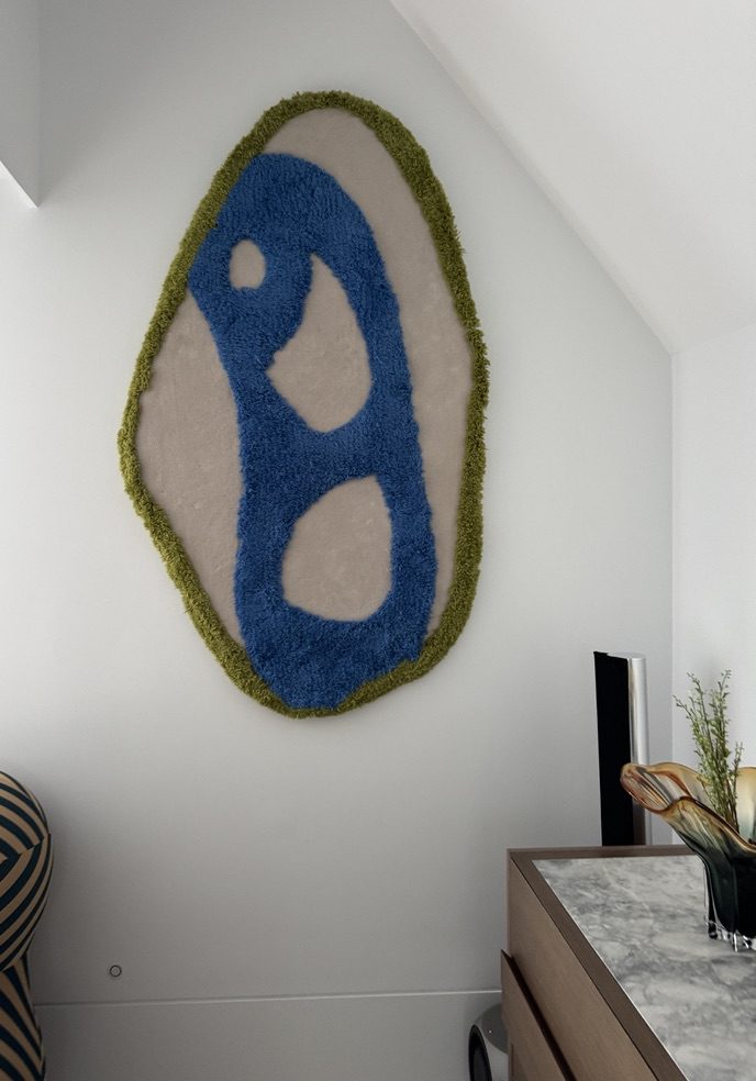 Organic oval wall rug in blue and cream with a green border