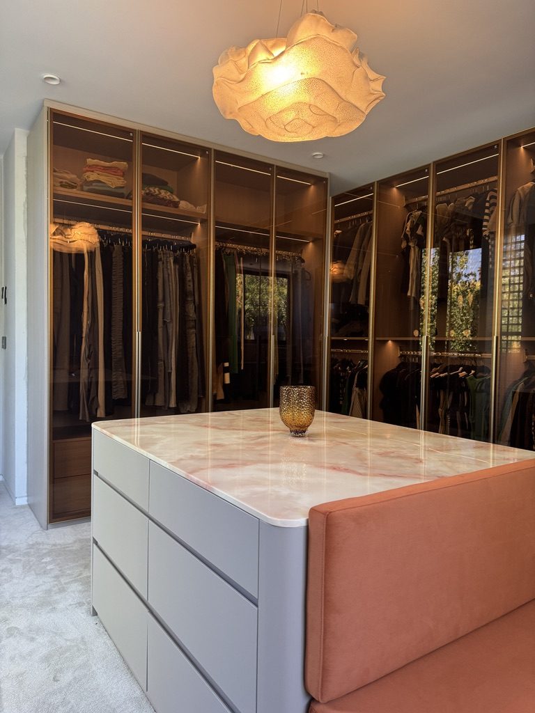 Walk-in robe with bronze glass wardrobes and a stone-topped island